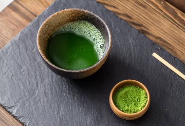 yeşil matcha çay prepearing taş siyah masada