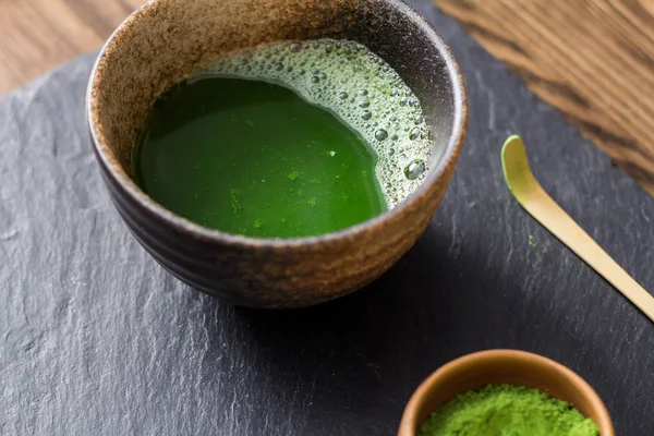 yeşil matcha çay prepearing taş siyah masada