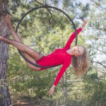 Fit vrouw in skinny skinny kleding dansen met luchtfoto zijde op de achtergrond van een bos, gymnast training op luchtfoto zijde