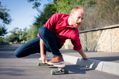 Kırmızı gömlek ve mavi jeans sahil yakınında longboard üzerinde sürme sırasında gündoğumu, deniz ya da okyanus arka plan patenci