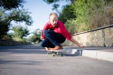 Kırmızı gömlek ve mavi jeans sahil yakınında longboard üzerinde sürme sırasında gündoğumu, deniz ya da okyanus arka plan patenci