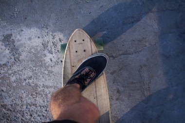 Kırmızı gömlek ve mavi jeans sahil yakınında longboard üzerinde sürme sırasında gündoğumu, deniz ya da okyanus arka plan patenci