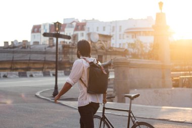 Sabah şehir sokakları, şık beared hipster üzerinde siyah Bisiklet ile genç modern buisinessman 