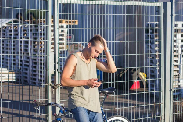 Young ,man walk with fixie bike, urban background, picture of hipster with bicycle in blue colors