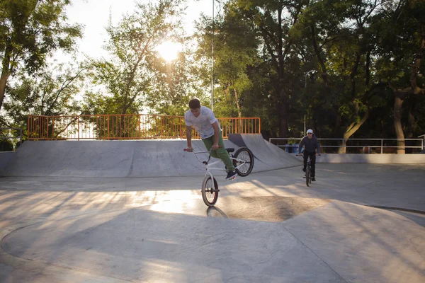 BMX rider training and do tricks in street plaza, bicyxle stunt rider in cocncrete skatepark
