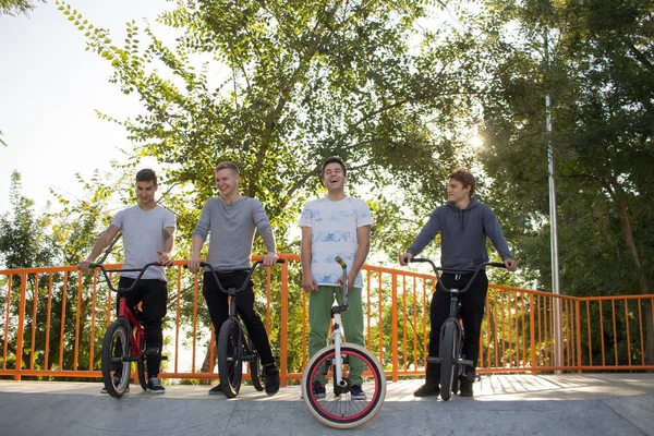 一群年轻人在滑冰广场的小轮车自行车 特技自行车骑手在滑板公园 — 图库照片