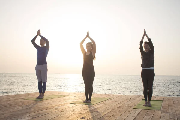 Grupul Oameni Din Yoga Pozează Stand Cheiul Lemn Răsăritul Soarelui — Fotografie, imagine de stoc