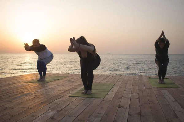 Grupul Oameni Din Yoga Pozează Stand Cheiul Lemn Răsăritul Soarelui — Fotografie, imagine de stoc