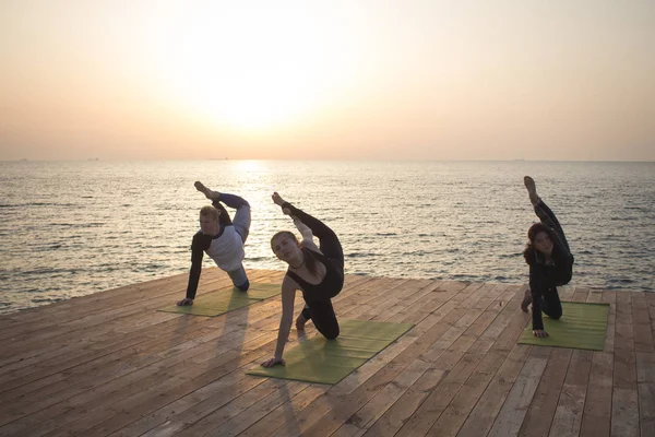 Grupul Oameni Din Yoga Pozează Stand Cheiul Lemn Răsăritul Soarelui — Fotografie, imagine de stoc