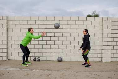 Gençler açık havada eğitim grup, sporcular birkaç koşucular yapmak egzersizleri, deniz veya nehir arka plan
