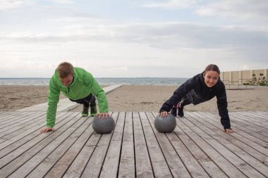 Gençler açık havada eğitim grup, sporcular birkaç koşucular yapmak egzersizleri, deniz veya nehir arka plan