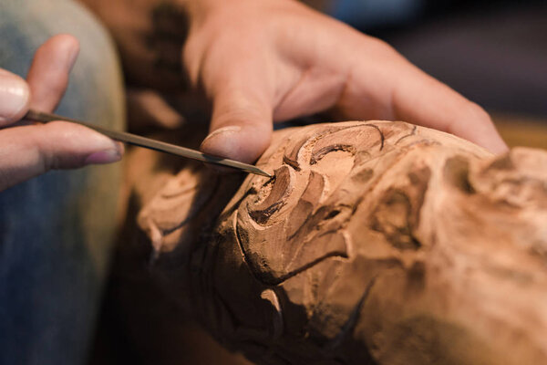 close up picture of woodcarver at work, handcrafting with wood