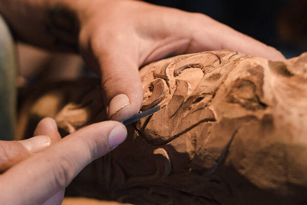 close up picture of woodcarver at work, handcrafting with wood