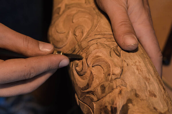 close up picture of woodcarver at work, handcrafting with wood