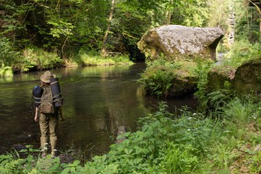 Bohem İsviçre Ulusal Parkı, Çek Cumhuriyeti'nin dağlarında kadın gezgin nehre yakın poz genç kadın uzun yürüyüşe çıkan kimse