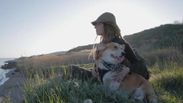 若い女性旅行者 山のコーギー犬とハイキング — ストック動画