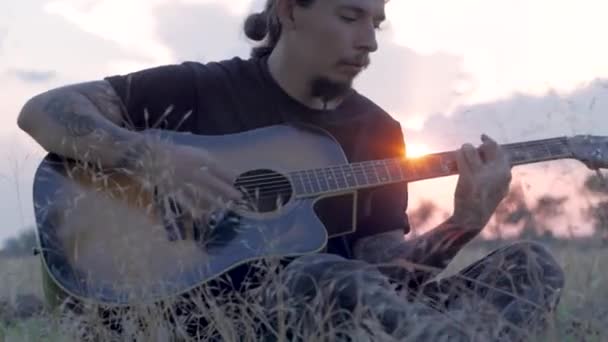 Ladí Tetovaný Samec Hrát Akustickou Kytaru Létě Pole Během Krásný — Stock video