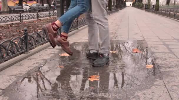 关闭皮靴在水坑 秋天潮湿的街道 — 图库视频影像