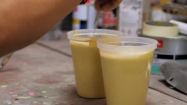 Araba boyama atölyesinde, işçi maskesi kullanın boya tabancası garajda.