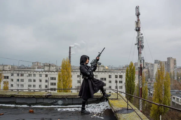 Genç kadın modern siyah techwear tarzı tüfekle poz çatı, Kızıl saçlı kadın cyperpunk veya sonrası kıyamet kavramı portresi