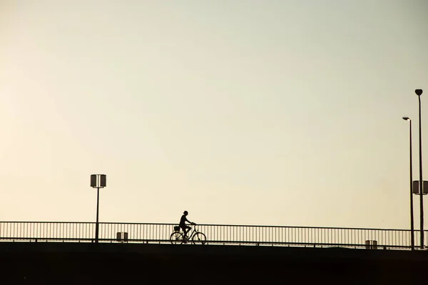 최소한의 풍경에 다리에 자전거 라이더의 실루엣 자전거 — 스톡 사진