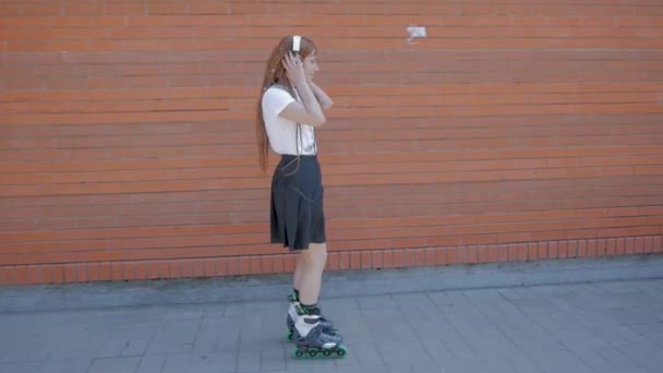 Jonge Vrouw Met Hoofdtelefoon Skaten Straten Het Luisteren Naar Muziek — Stockvideo