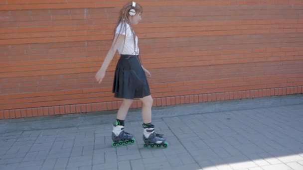 戴着耳机的年轻女子在街头滑旱冰 听音乐 — 图库视频影像
