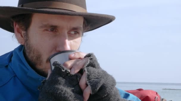 Young Bearded Hiker Blue Jacket Hat Drink Coffee Tea Beach — Stock Video