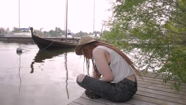 Νεαρή Γυναίκα Ταξιδιώτης Κάθεται Ξύλινη Προβλήτα Κοντά Στον Ποταμό Βάρκες — Αρχείο Βίντεο