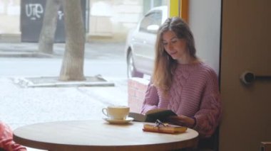 Genç kadın kakao marshmallows ile içki ve kitap okumak