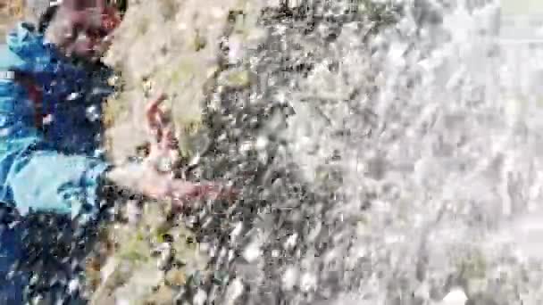 山の中の滝の近くの青いジャケットの若い男旅行者 — ストック動画
