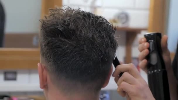 理髪店で髪型を取得する男のクローズ 仕事で男性のヘアスタイリスト — ストック動画