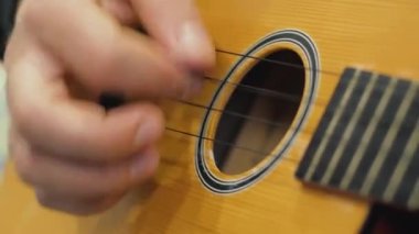 Ukulele üzerinde elektronik Tuner ile ayarlama ve oynama süreci yakın yukarı