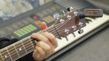 Elektronik Tuner yakın yukarı ile akustik gitar tuning süreci