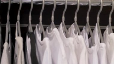 Dükkanda bir askı üzerinde birçok t-shirt yakın