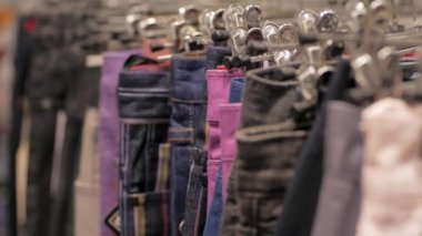 Dükkanda bir askı üzerinde birçok kot yakın