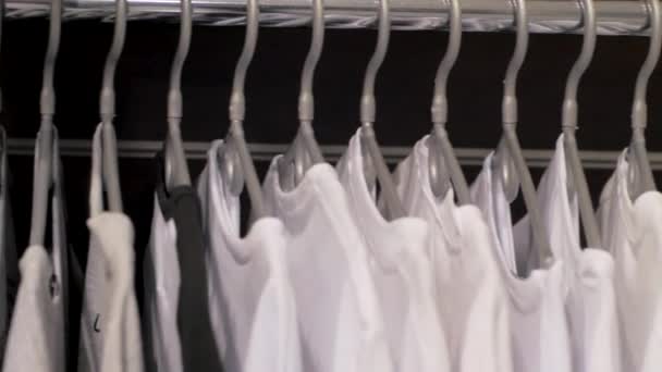 Nahaufnahme Vieler Shirts Auf Einem Kleiderbügel Geschäft — Stockvideo