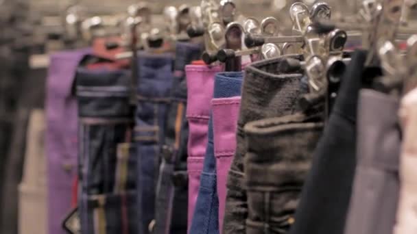 在商店的衣架上关闭许多牛仔裤 — 图库视频影像