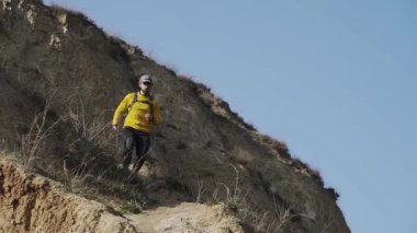 Güneşli bir gün tepede sırt çantası eğitimi ile genç erkek Trail Runner