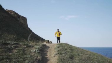 Güneşli bir gün tepede sırt çantası eğitimi ile genç erkek Trail Runner