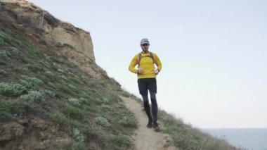 Güneşli bir gün tepede sırt çantası eğitimi ile genç erkek Trail Runner