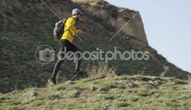 Güneşli bir gün tepede sırt çantası eğitimi ile genç erkek Trail Runner