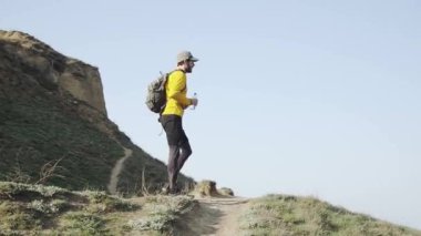Güneşli bir gün tepede sırt çantası eğitimi ile genç erkek Trail Runner