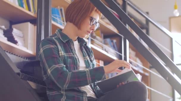 Jeune Rousse Femme Lunettes Lire Livre Dans Bibliothèque — Video