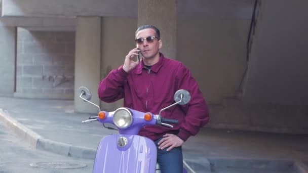 カラフルなモータースクーターを持つ若いスタイリッシュオス — ストック動画