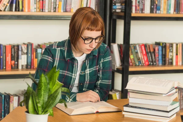 Młoda Ruda Kobieta Okularach Czytać Książkę Bibliotece — Zdjęcie stockowe