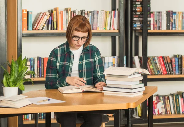 Młoda Ruda Kobieta Okularach Czytać Książkę Bibliotece — Zdjęcie stockowe