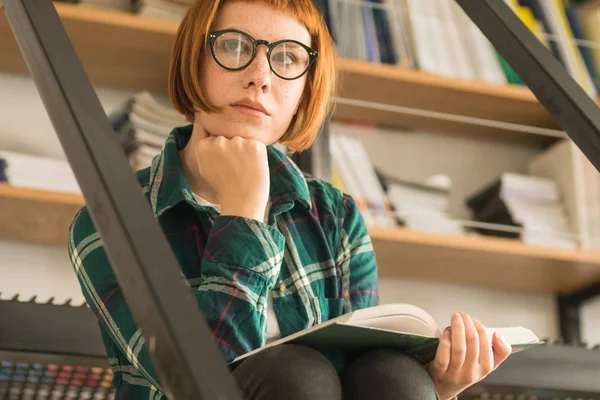 Młoda Ruda Kobieta Okularach Czytać Książkę Bibliotece — Zdjęcie stockowe