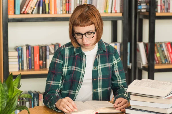 Młoda Ruda Kobieta Okularach Czytać Książkę Bibliotece — Zdjęcie stockowe