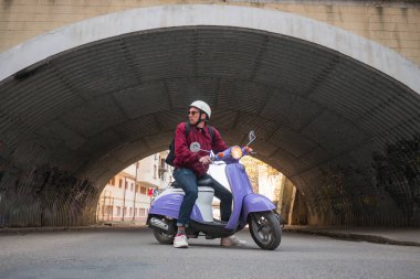 Renkli motor scooter ile genç şık erkek